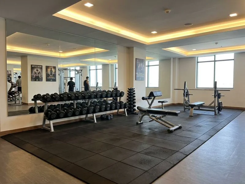 Modern gym with free weights section at Hotel Aram