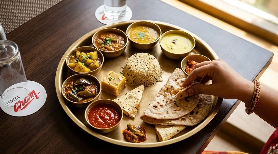 Authentic Gujarati thali spread with rotis, subzis, dal, and sweet preparations